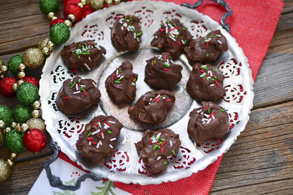 A tray of peanut cluster candy sitting on a christmas napkin.