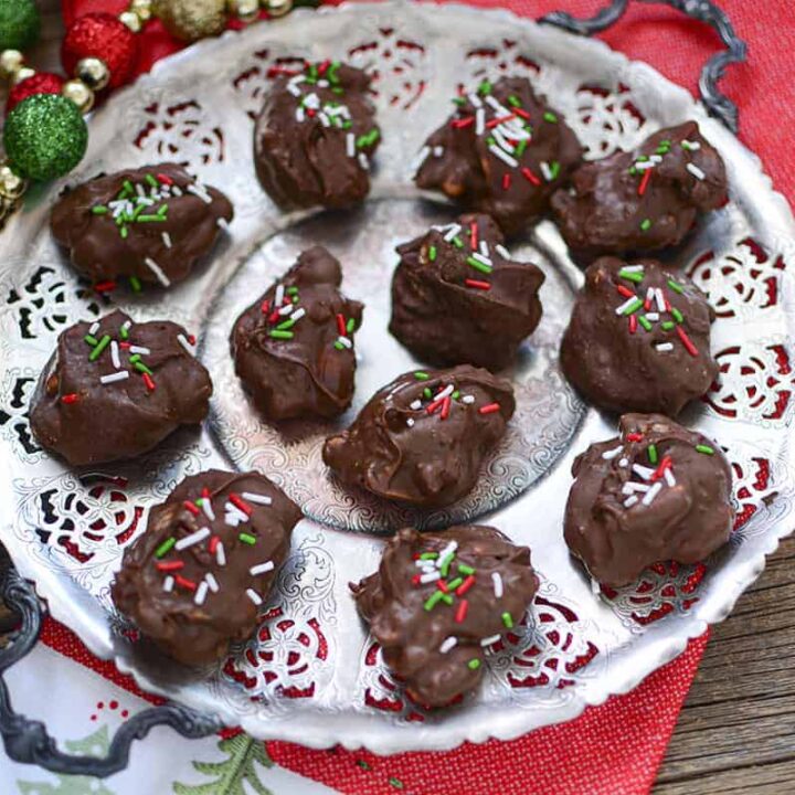 A tray of peanut cluster candy sitting on a christmas napkin.