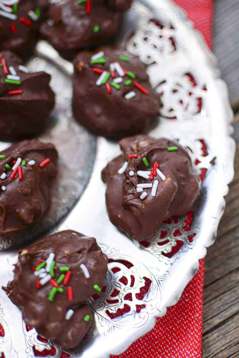 Three moose poop candies on a silver tray with a red napkin underneath.