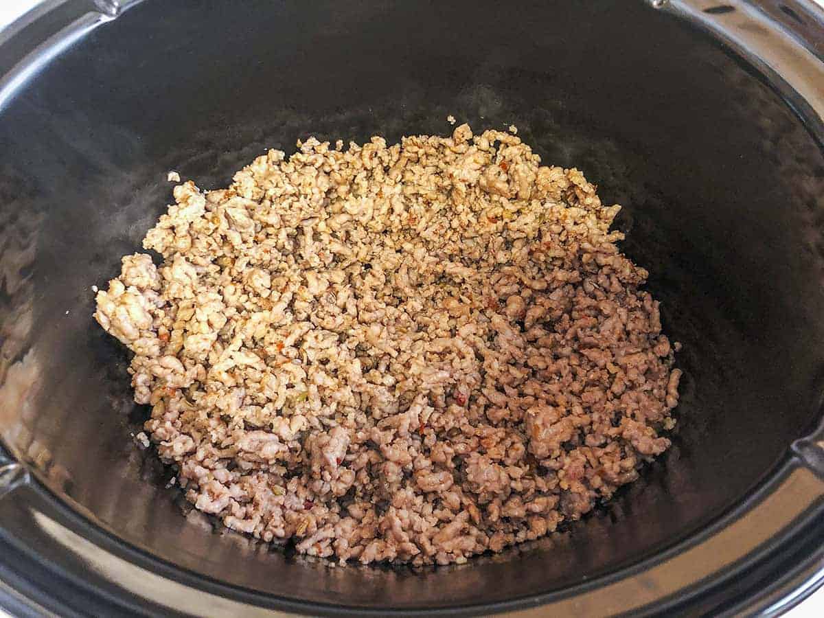 Browned crumbled sausage placed into the slow cooker.
