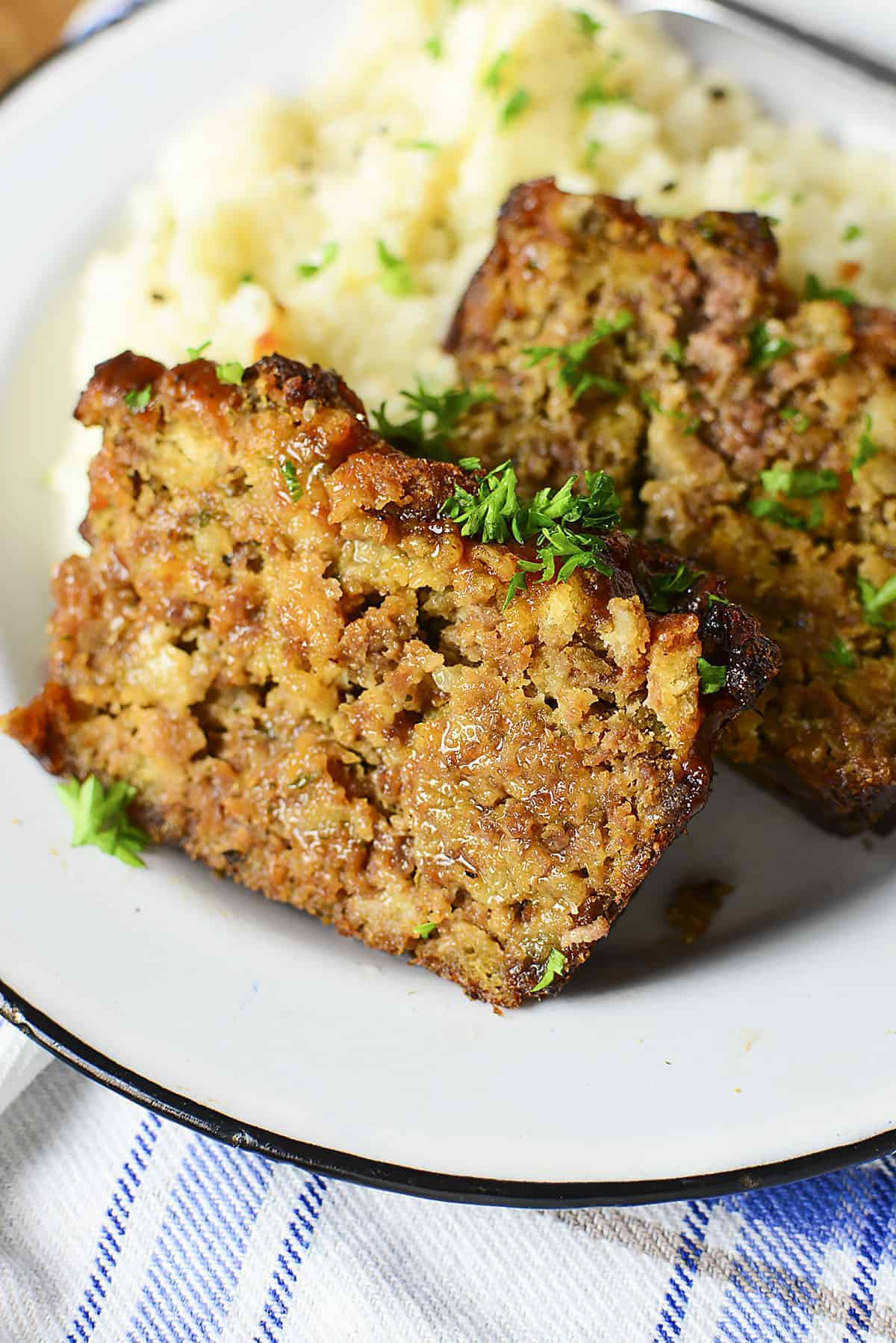 A slice of meatloaf served with mashed potatoes. 