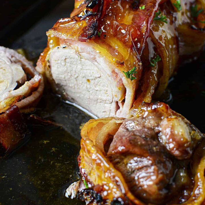 Apricot glazed pork tenderloin sliced on a black cast iron pan.