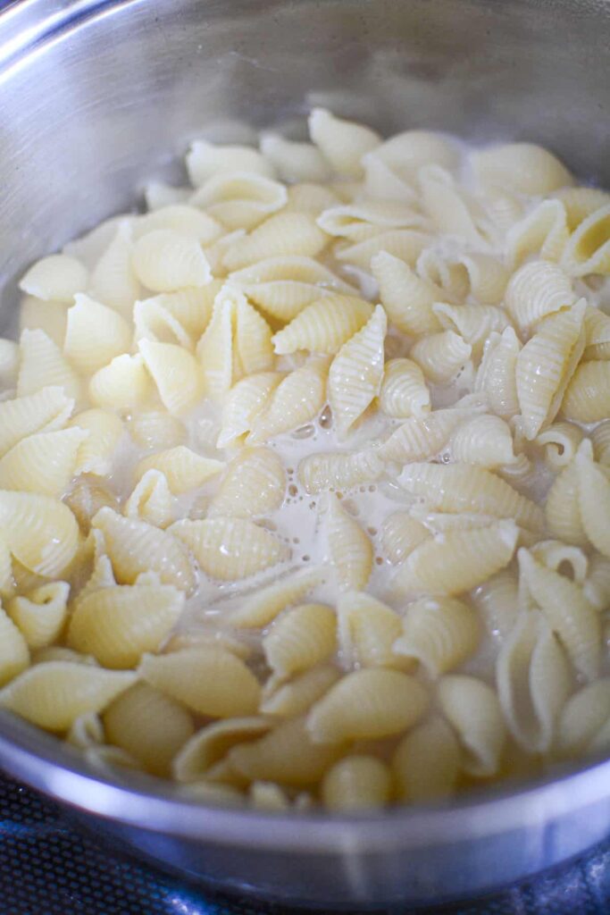 Cooked pasta with evaporated milk in the pot.