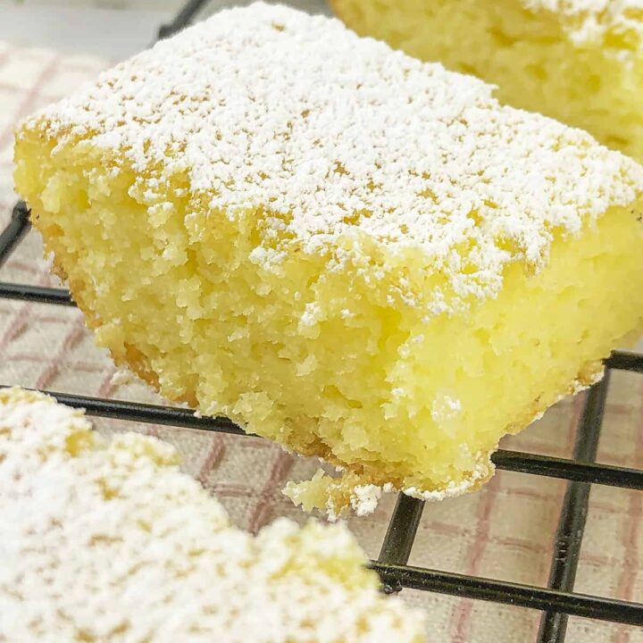 A lemony flavored dessert bar on a black cooling rack.