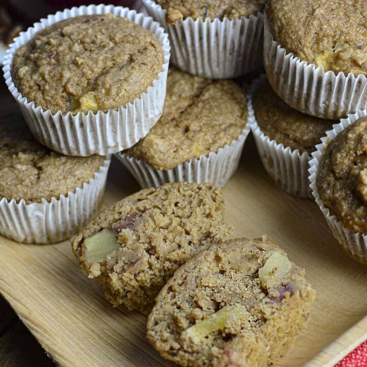 Apple muffins piled on top of eachother with one cut in half to see the inside.