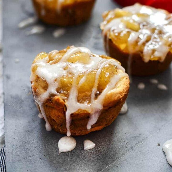 Cinnamon roll apple pie cups on a slate serving board.