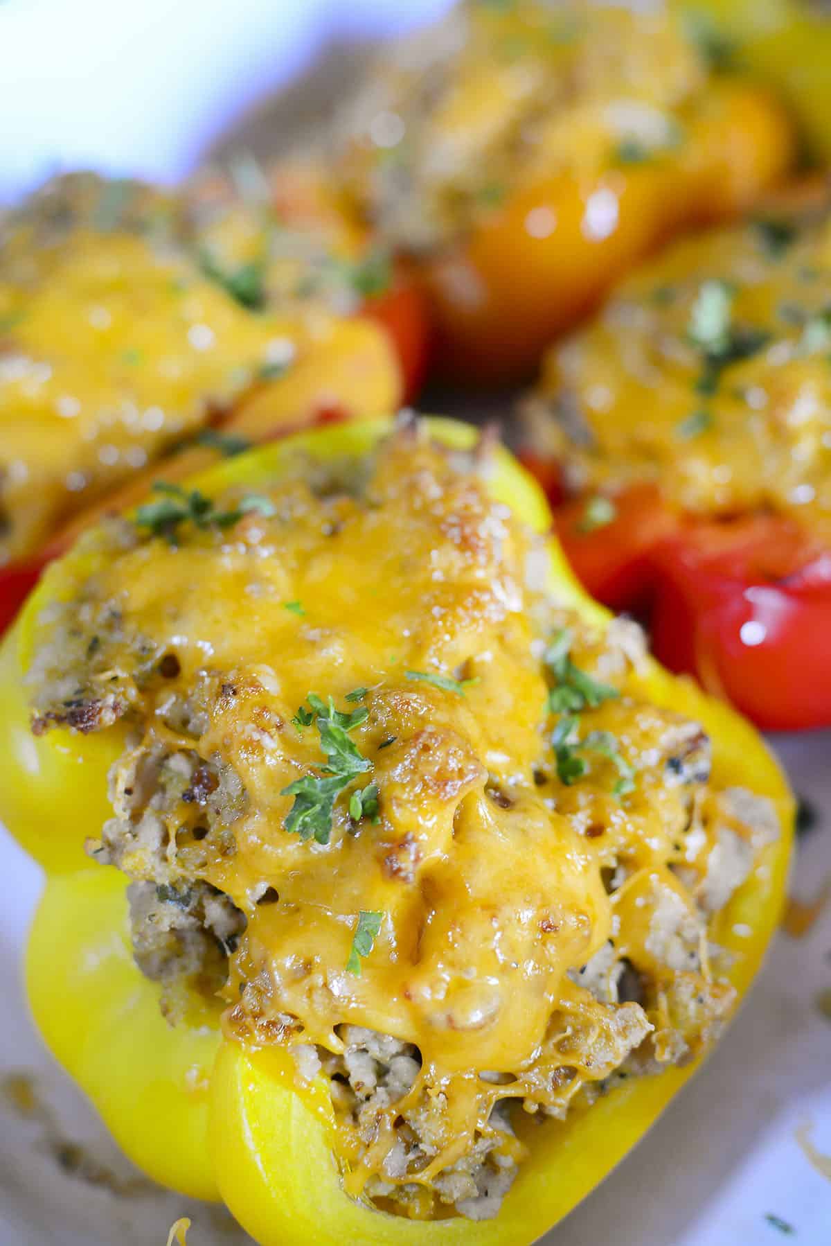 A yellow bell peppers stuffed with chicken and topped with cheese.