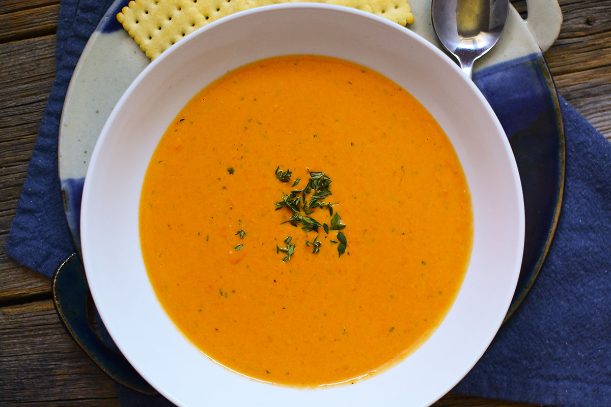 Pictured from overhead, the bowl of soup is in a white bowl with crackers around the top.