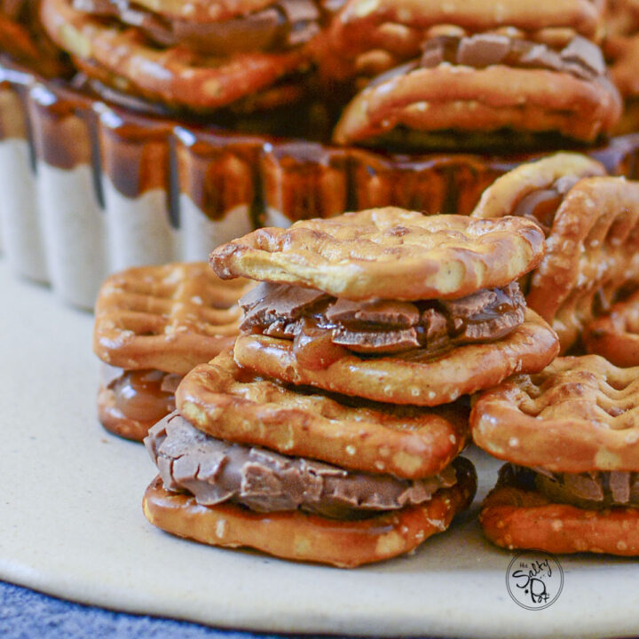 Rolo and Pretzel Bites stacked two high on a cream colored plate.