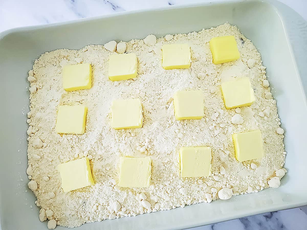 12 pats of butter placed on top of the dry cake mix, ready to go into the oven to bake.