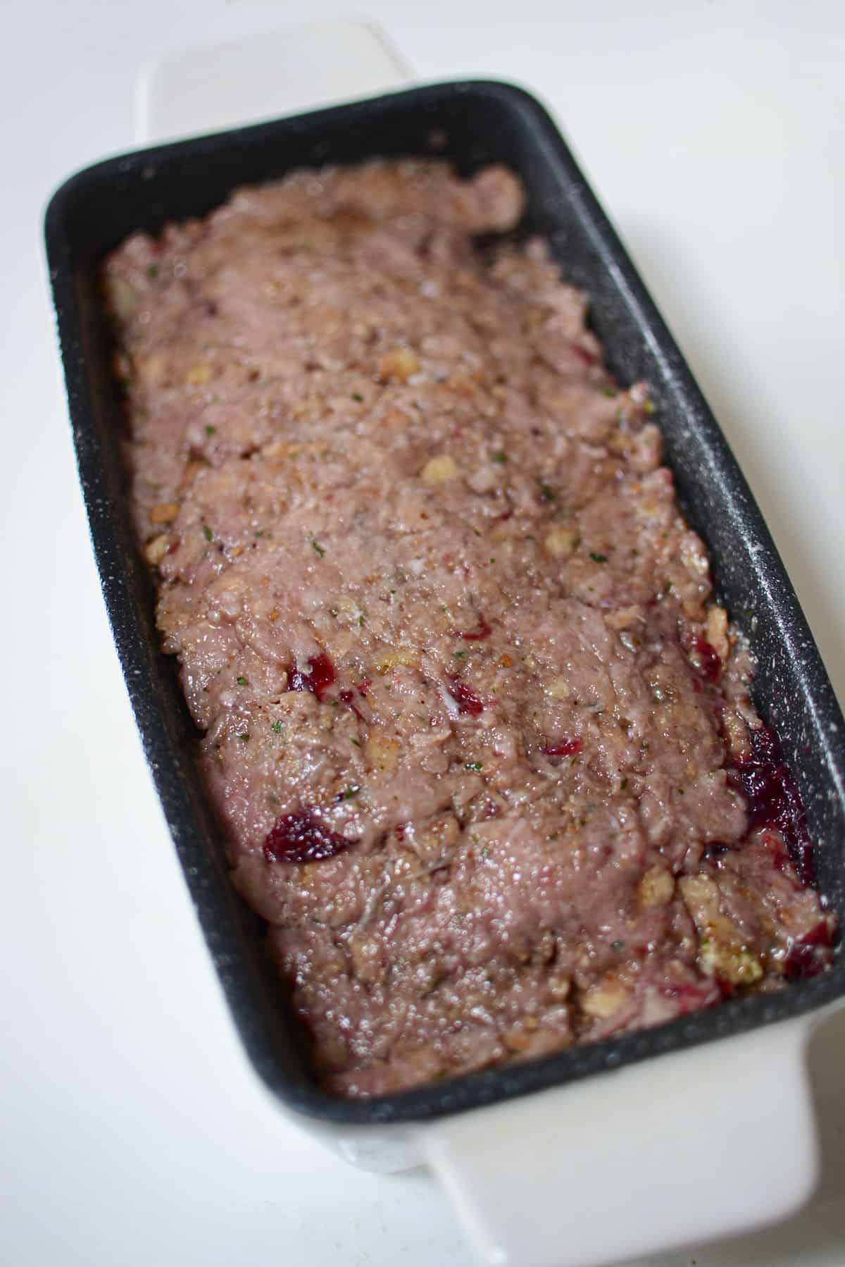 The raw turkey meatloaf in a loaf pan, ready to go into the oven.
