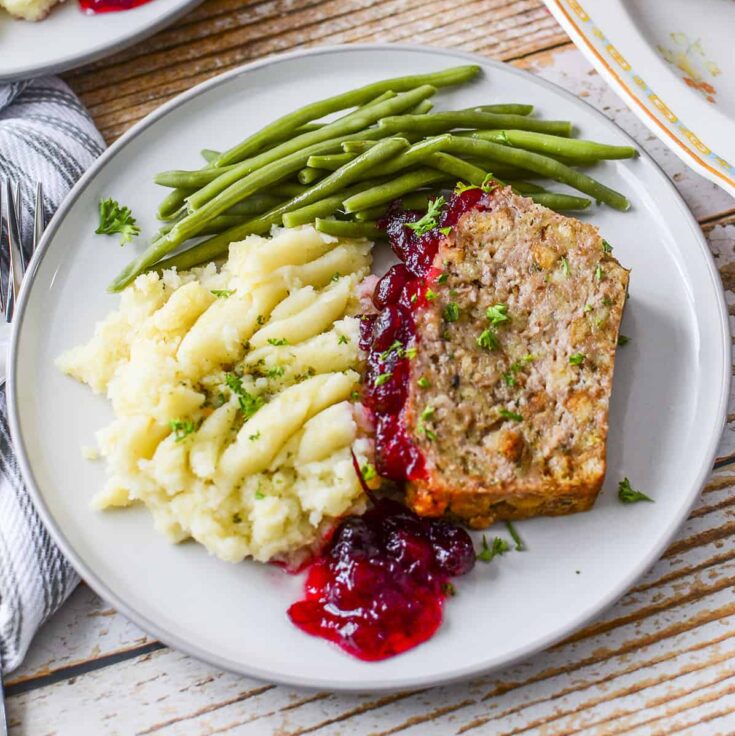 A dinner plate with 4 ingredient stove top turkey meatloaf with cranberry sauce.