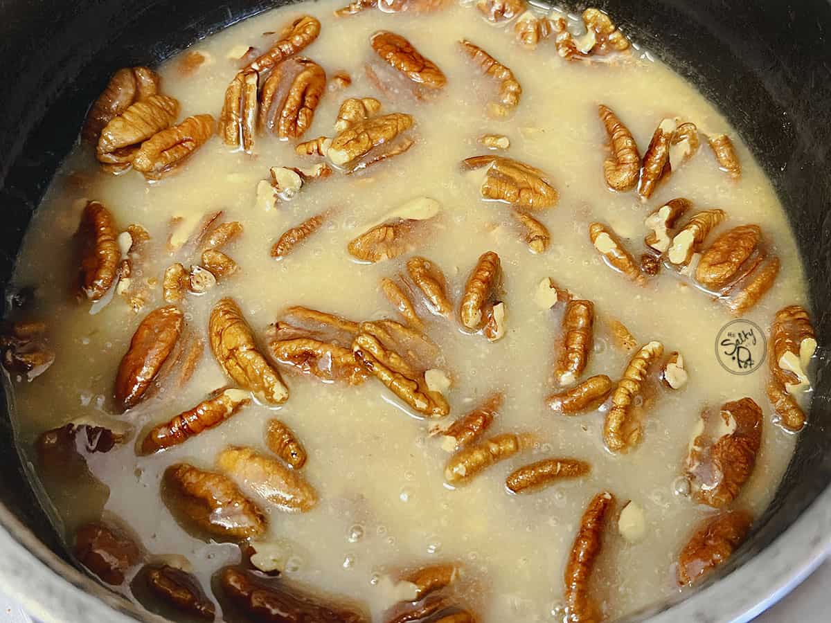 Pecans are added to the butter and sugar mixture.