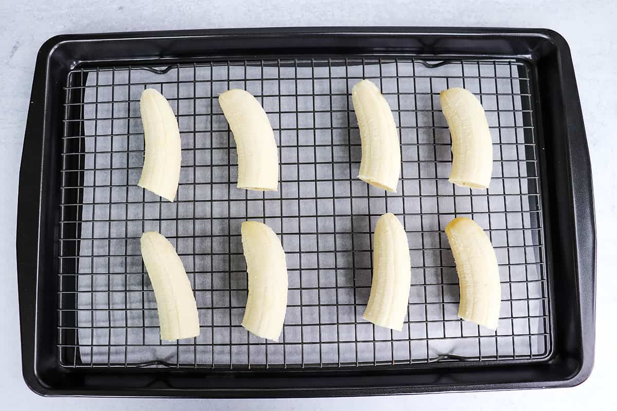Ripe bananas cut in half on a tray. 