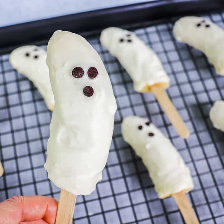 One close up banana ghost pop with others in a tray in the background.