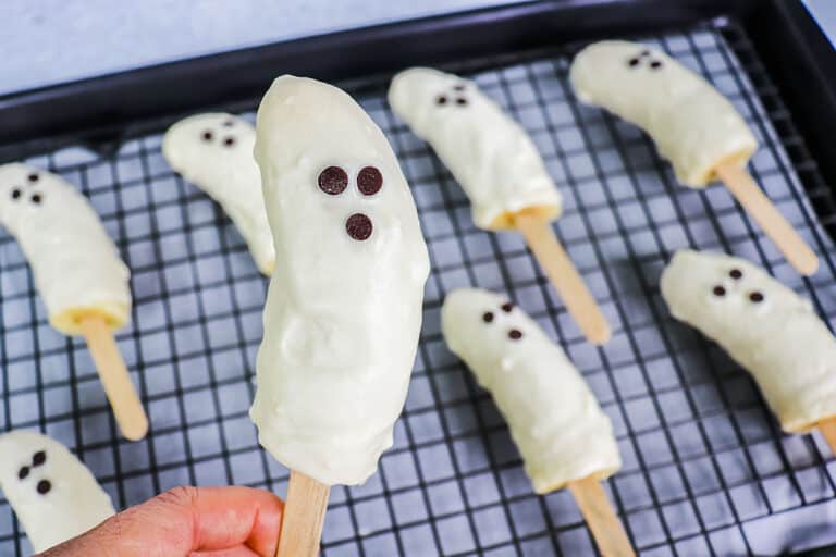 One close up banana ghost pop with others in a tray in the background.