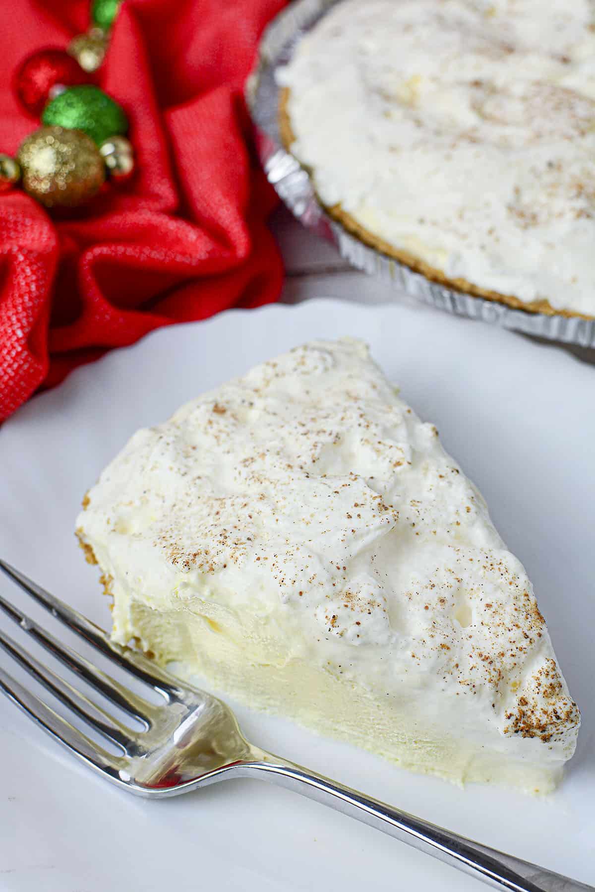 Eggnog pie on a white plate with freshly grated nutmeg sprinkled over top.