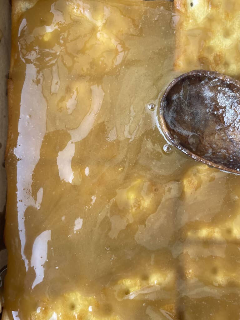 The caramel is poured over the crackers, ready to go into the oven.
