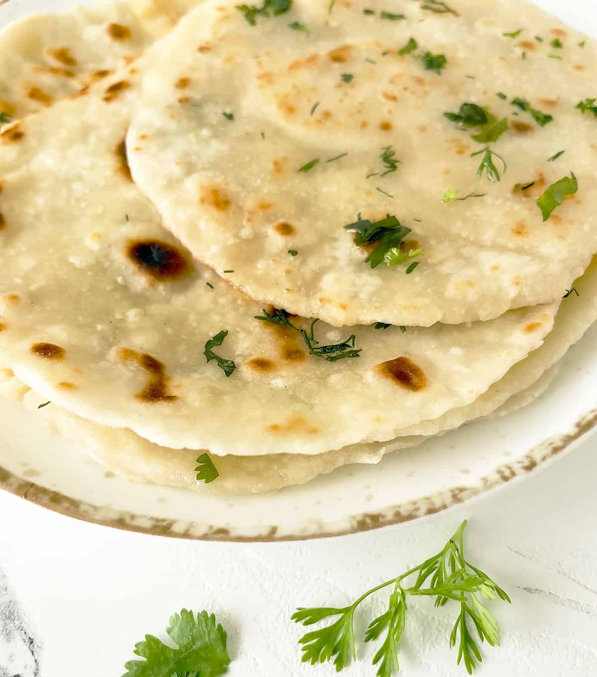 Naan bread with parsley sprinkled over top. 