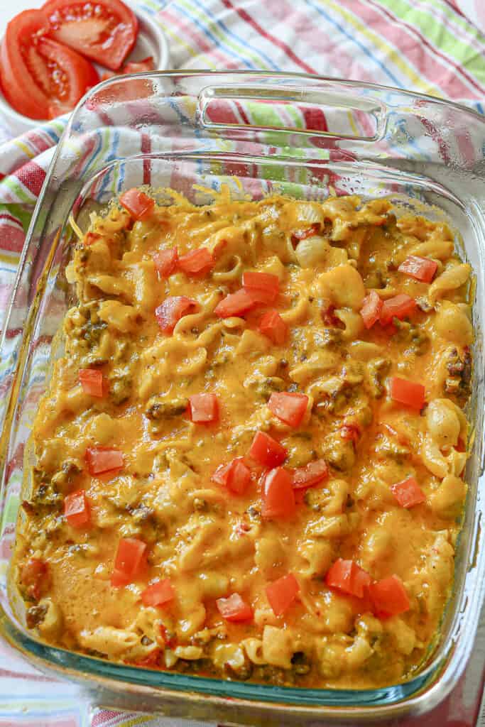 Cheesburger casserole out of the oven with fresh tomatoes on top in a glass baking dish.