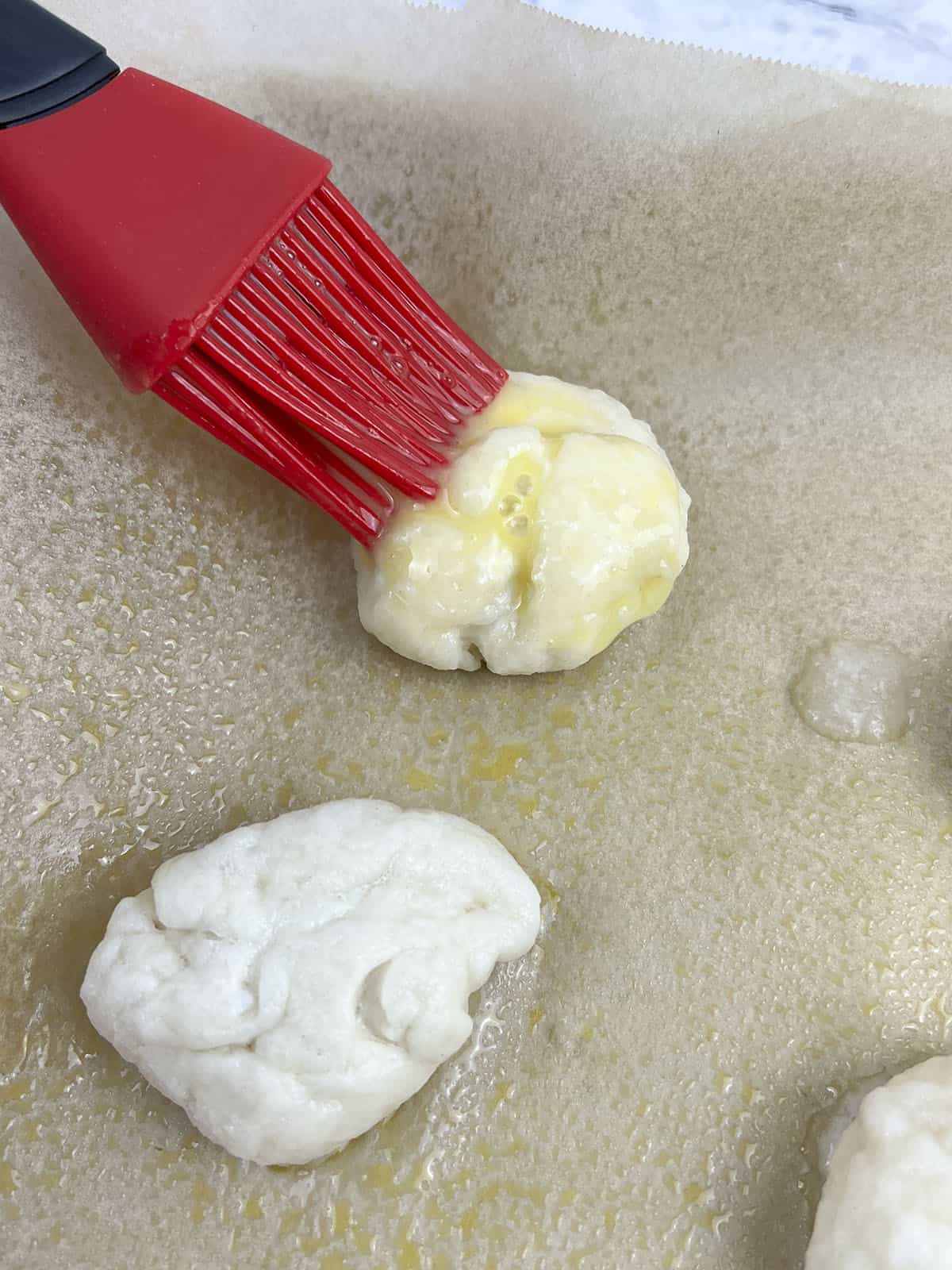 Brushing on the egg wash with a red silicone brush.