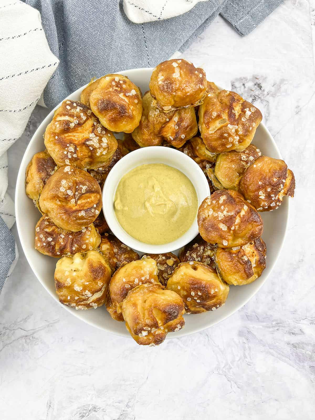 A bowl of pretzel knots with cheese dip in the center.