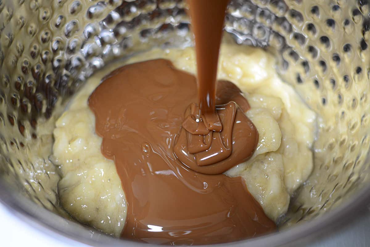 Pouring the caramel sauce into the mashed bananas.