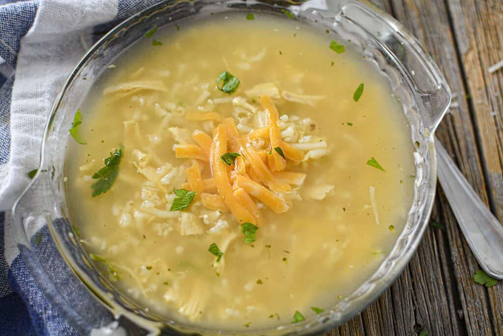 The chicken cheddar soup is garnished with grated cheddar over top. 