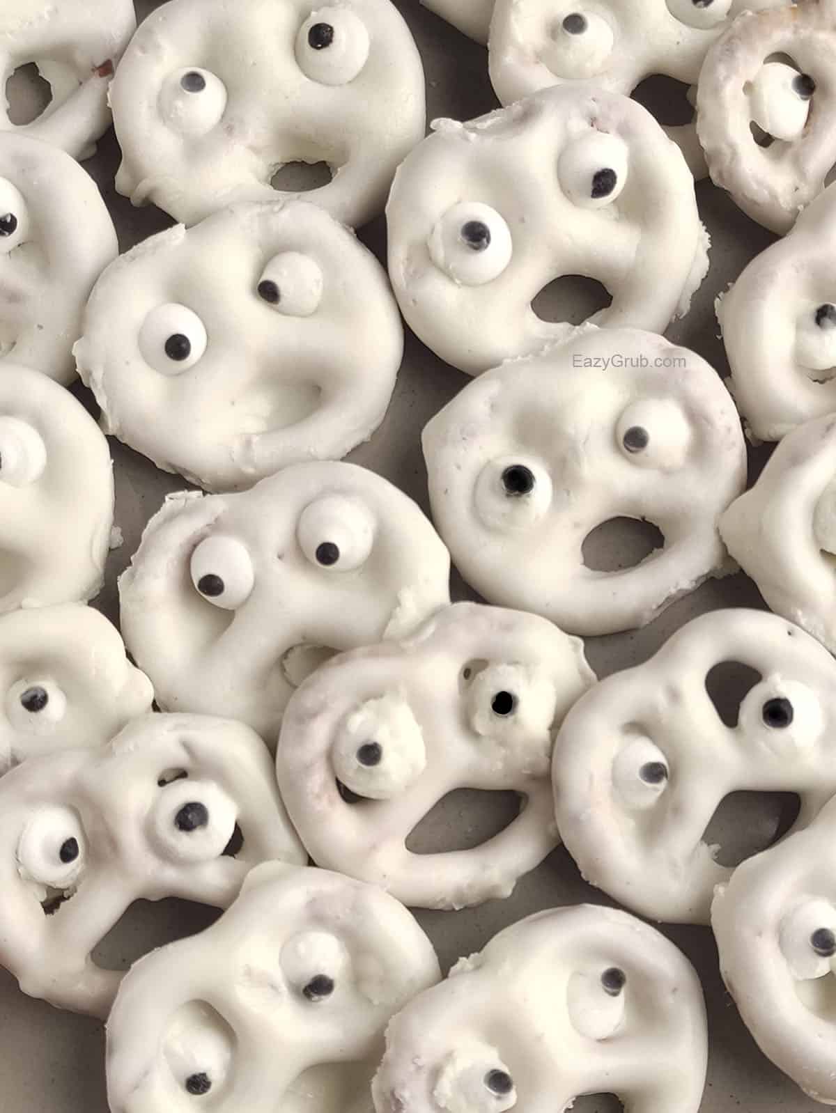 A close up of Pretzel ghosts on a grey plate.