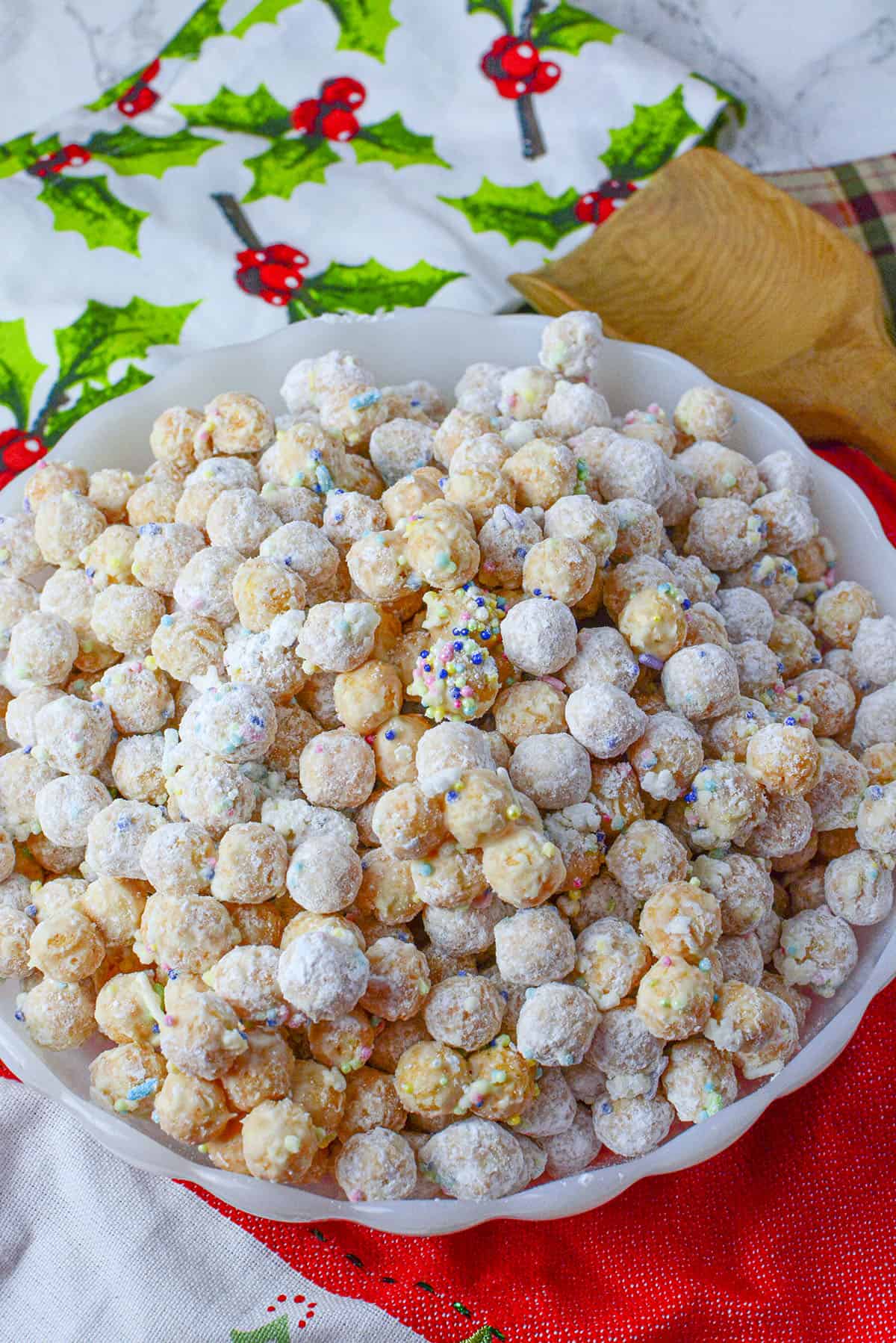 Snowy looking corn pop cereal with sprinkles in a white bowl on a red holiday napkin.