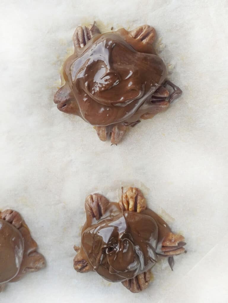 Melted chocolate poured on top of the caramel to form the turtle shell.