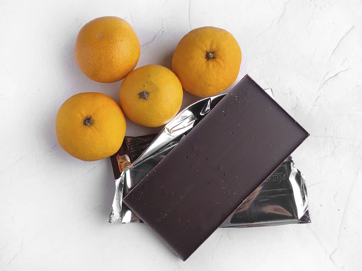 The ingredients needed for this recipe. Shown are 4 oranges and a large block of chocolate.