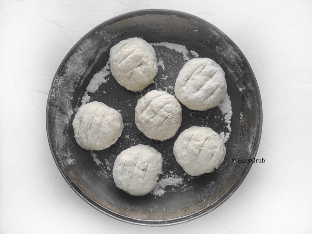 6 dough balls in a baking tray.