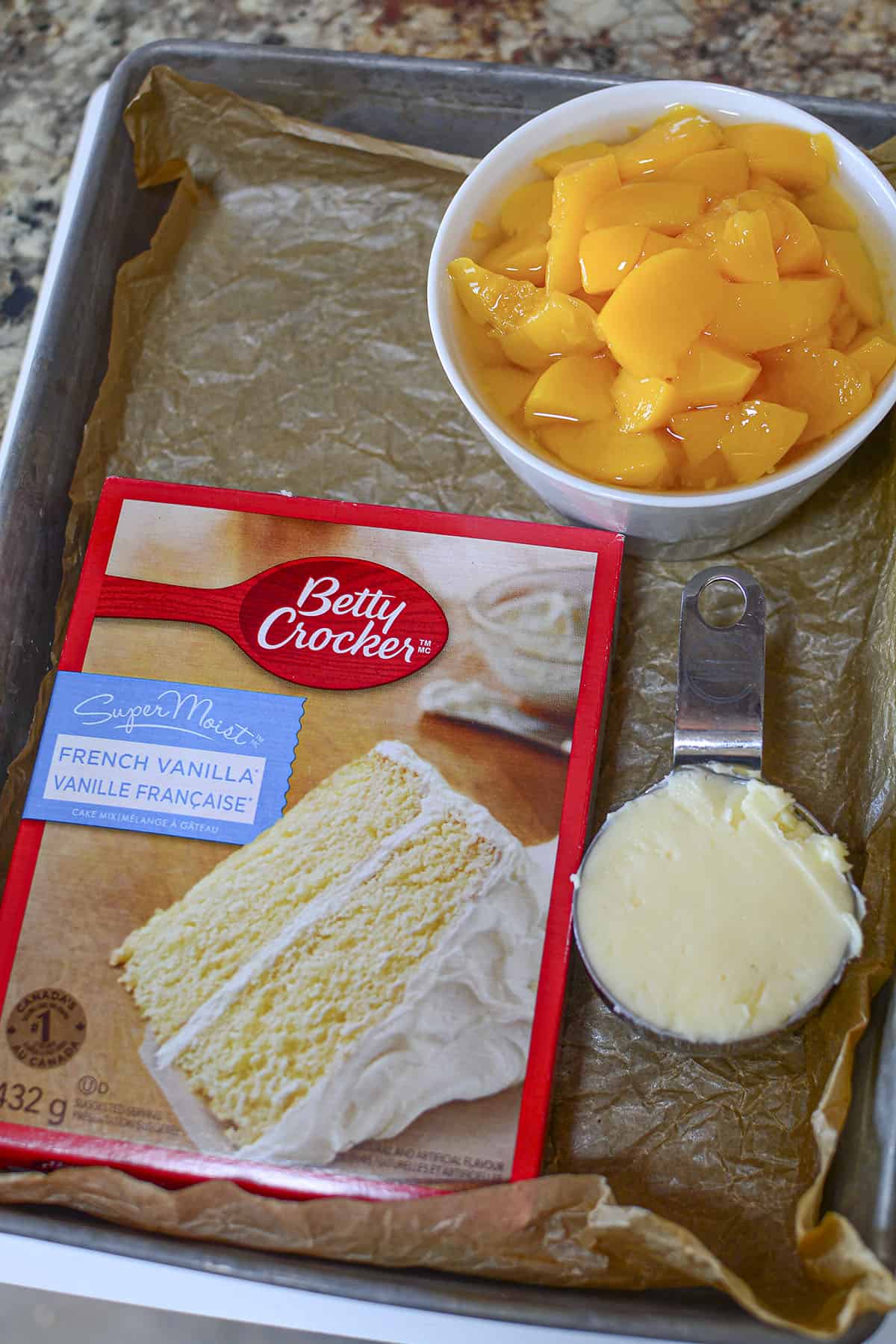 Ingredients for the cobbler. Peaches, butter and a french vanilla cake mix.