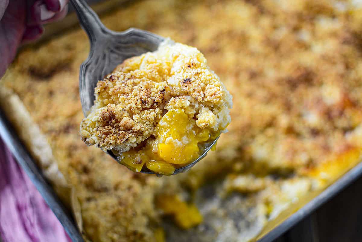 A spoonful of the cobbler in a large serving spoon. 