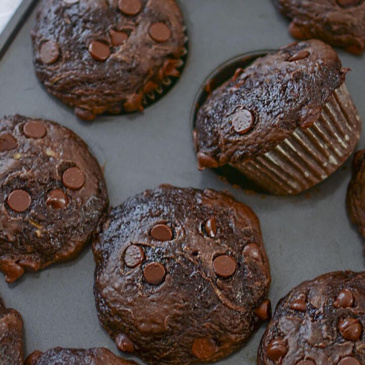 4 three ingredient chocolate zucchini muffins in a baking pan.