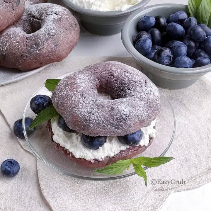 A 3 ingredient blueberry bagel on a plate with a linen napkin.