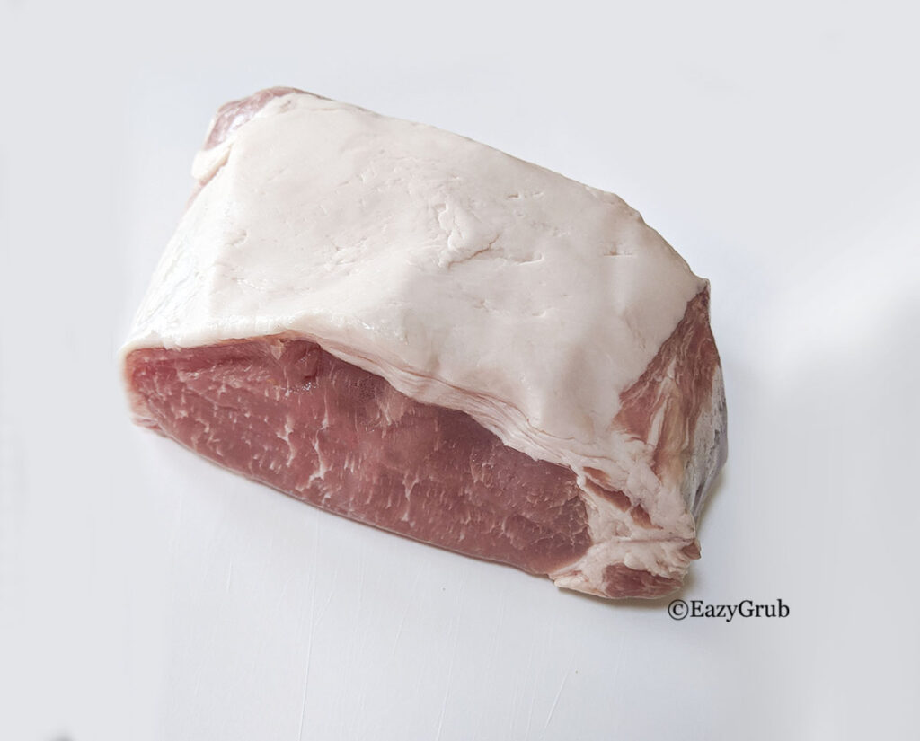 A pork loin roast on a white cutting board.