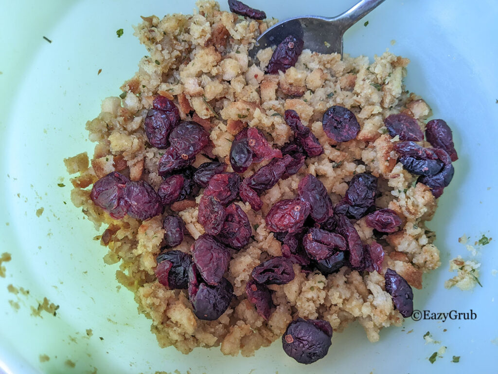 Stuffing with cranberries added to it, in a green bowl.