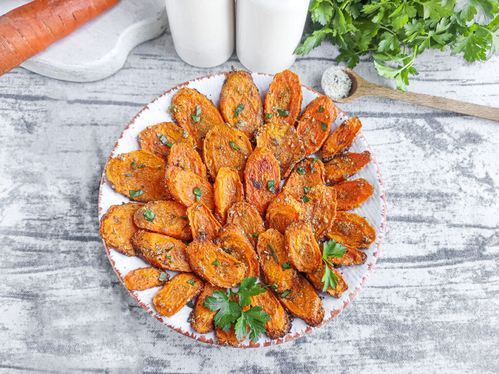 Carrots with ranch seasoning on a plate sprinkled with parsley.