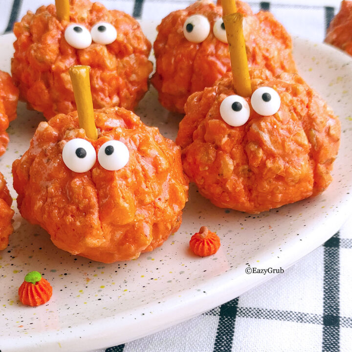 4 pumpkin puff cereal treas on a plate with googly candy eyes.
