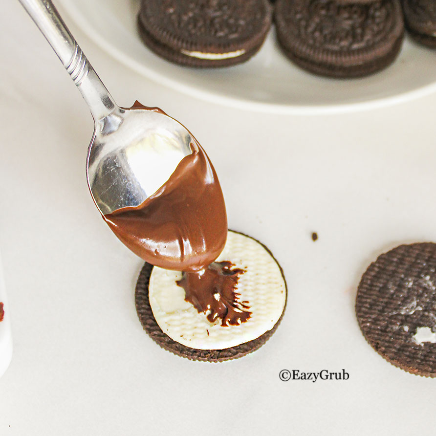Melted chocolate on a spoon, dripping some onto the oreo icing.