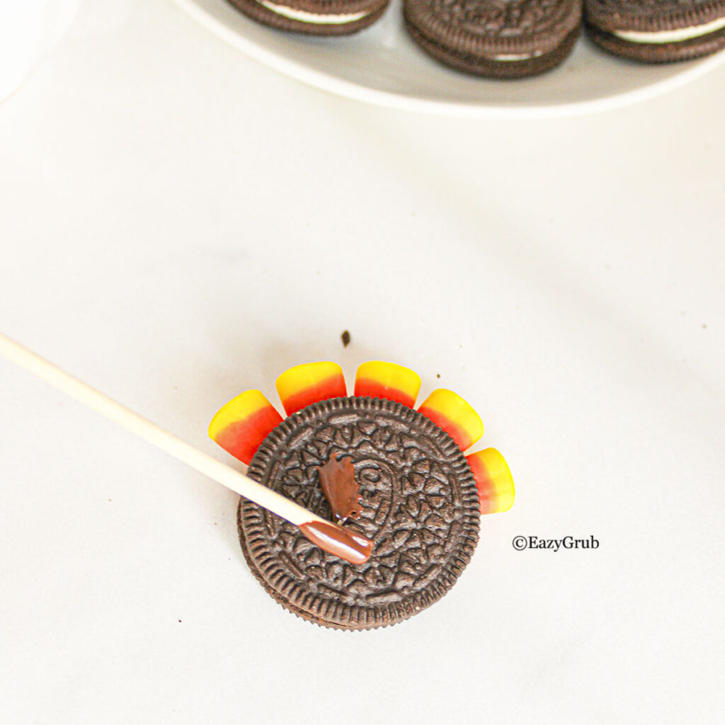 melted chocolate placed on the center of the top cookie on the oreo.