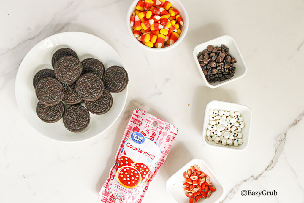 Ingredients to make the turkey oreos. Oreos, candy corn, chocolate chips, candy eyes, orange reeses pieces and red cookie icing.