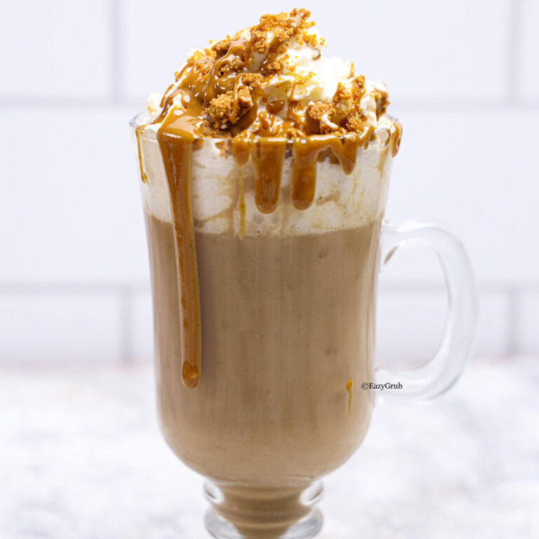 A mug of biscoff hot chocolate, top it with a mountain of whipped cream, and drizzle that melty Biscoff