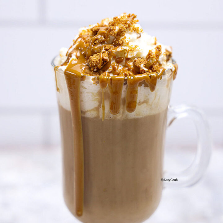 overhead image of Biscoff hot chocolate topped with whipped cream, and drizzle that melty Biscoff