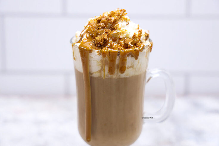 overhead image of Biscoff hot chocolate topped with whipped cream, and drizzle that melty Biscoff
