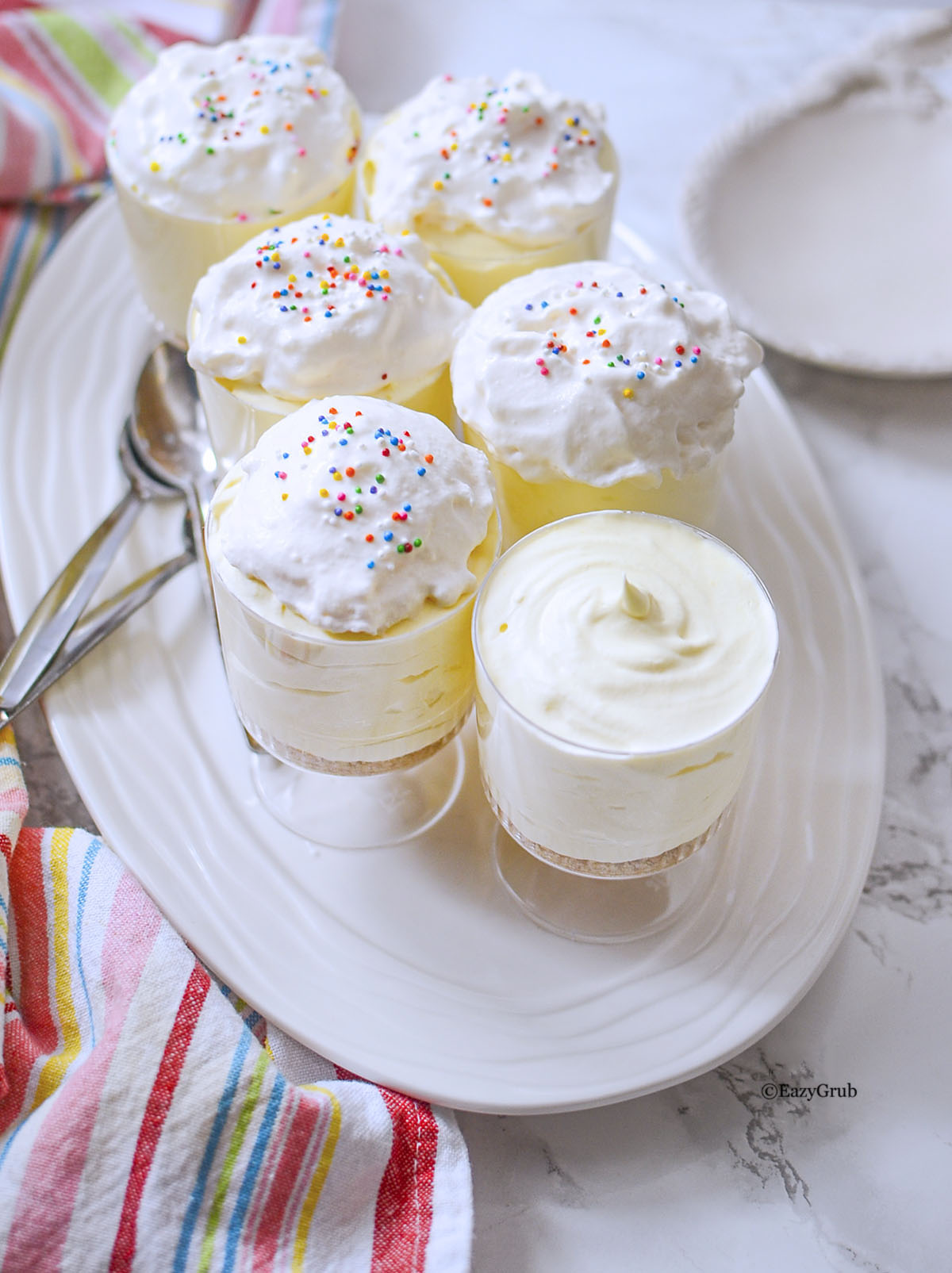 Overhead view of lemon cheesecake cups arranged on a serving tray.
