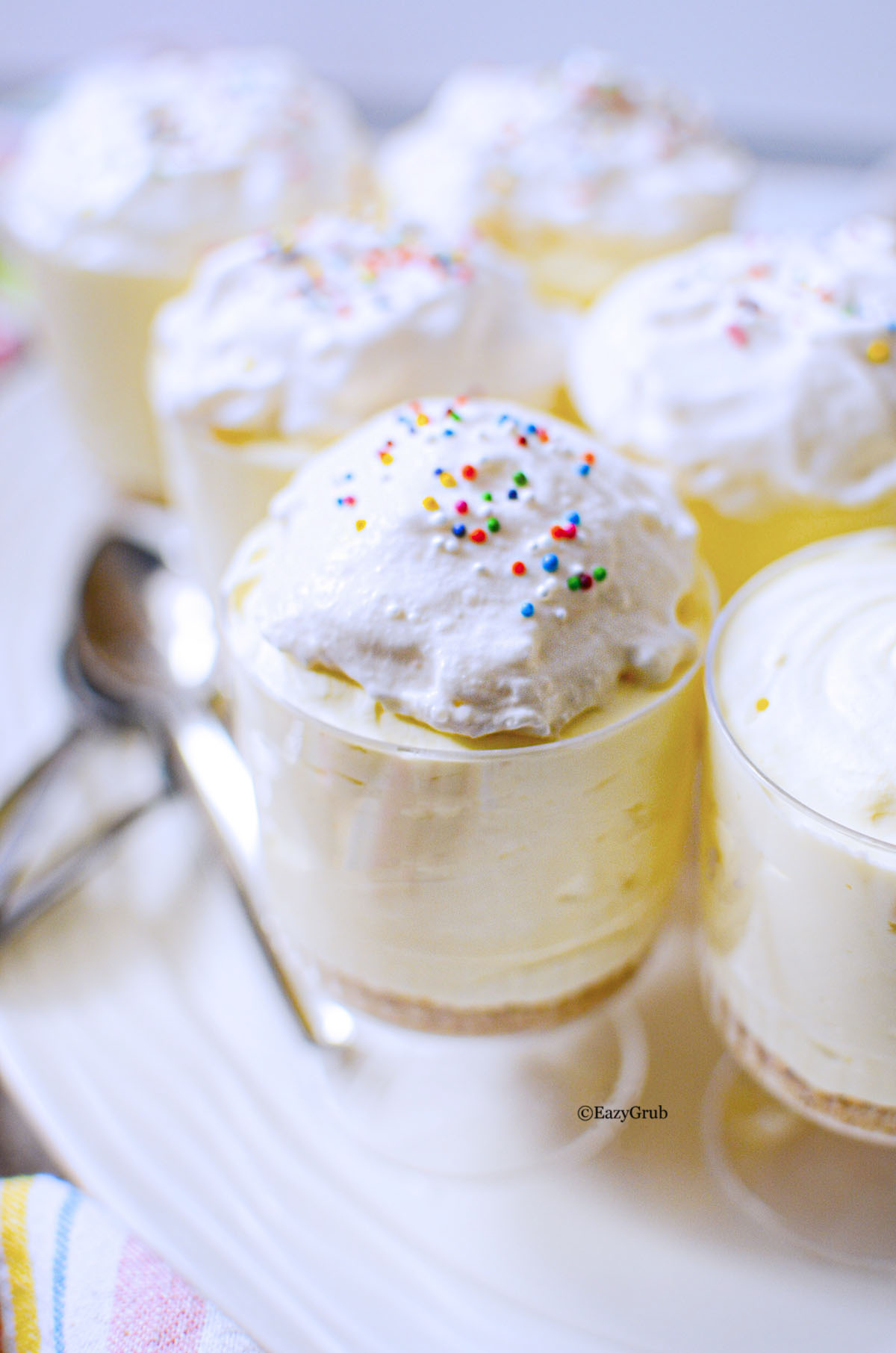 Overhead view of lemon cheesecake cups arranged on a serving tray.