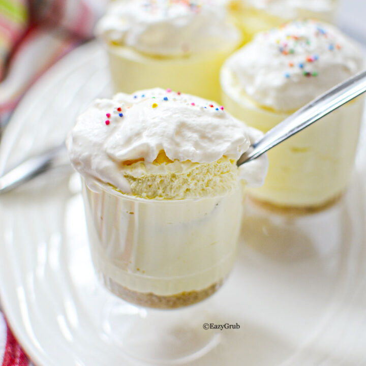 Spoon scooping lemon cheesecake dessert cup showing fluffy texture
